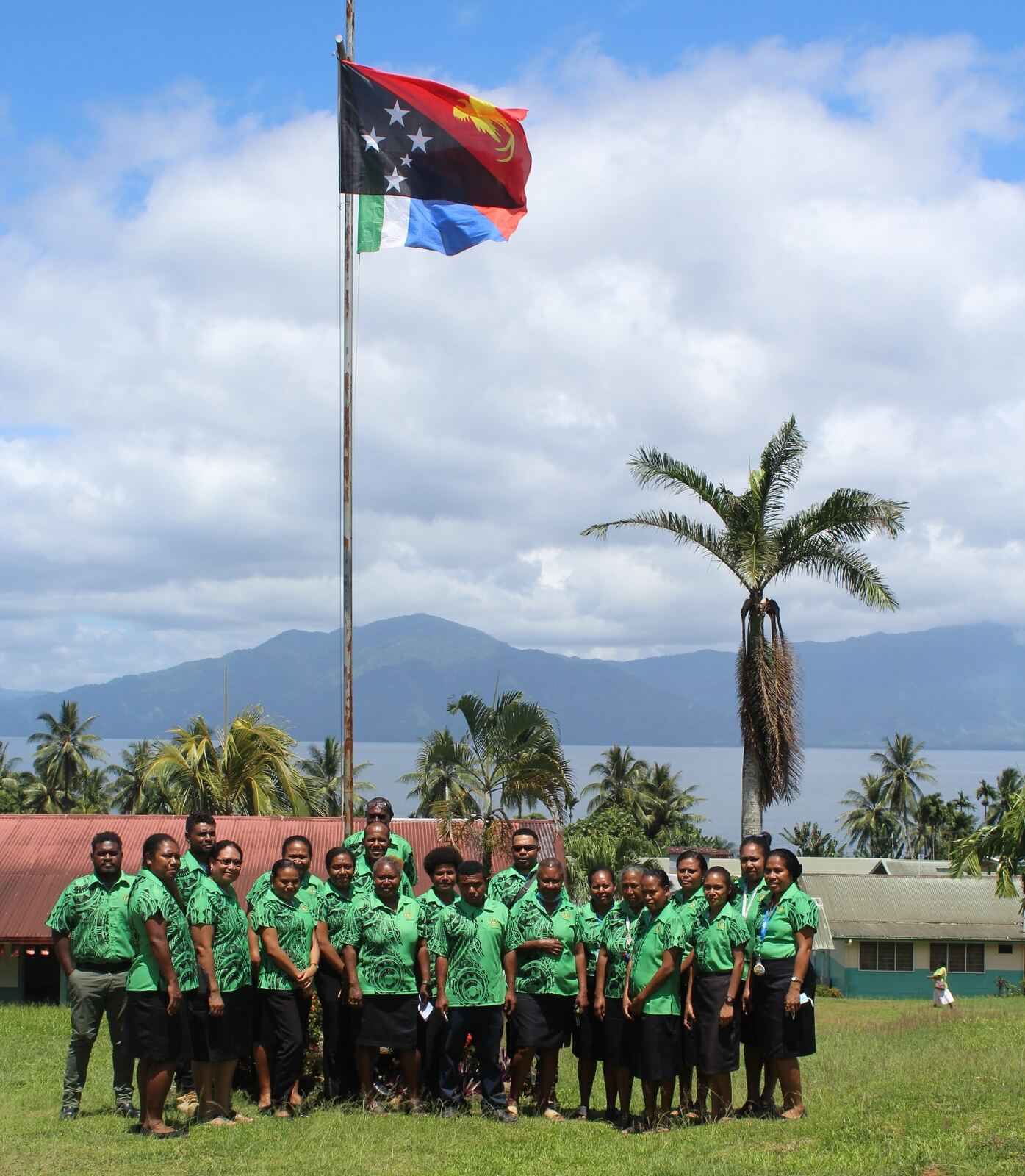 MBPHA staff beneath the national flag in Alotau, overlooking Milne Bay.